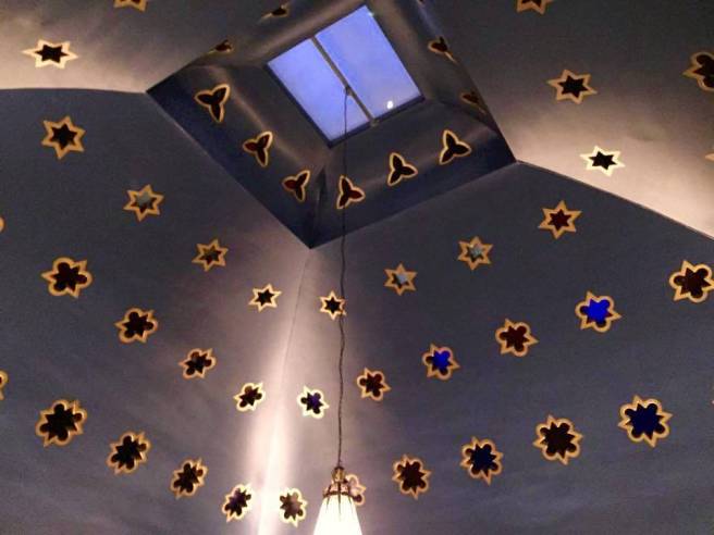 The dome of the Turkish suite with a central skylight and rows of small star-shaped red and blue glass windows